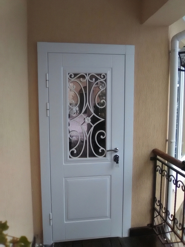 Остекленная дверь с белой ковкой